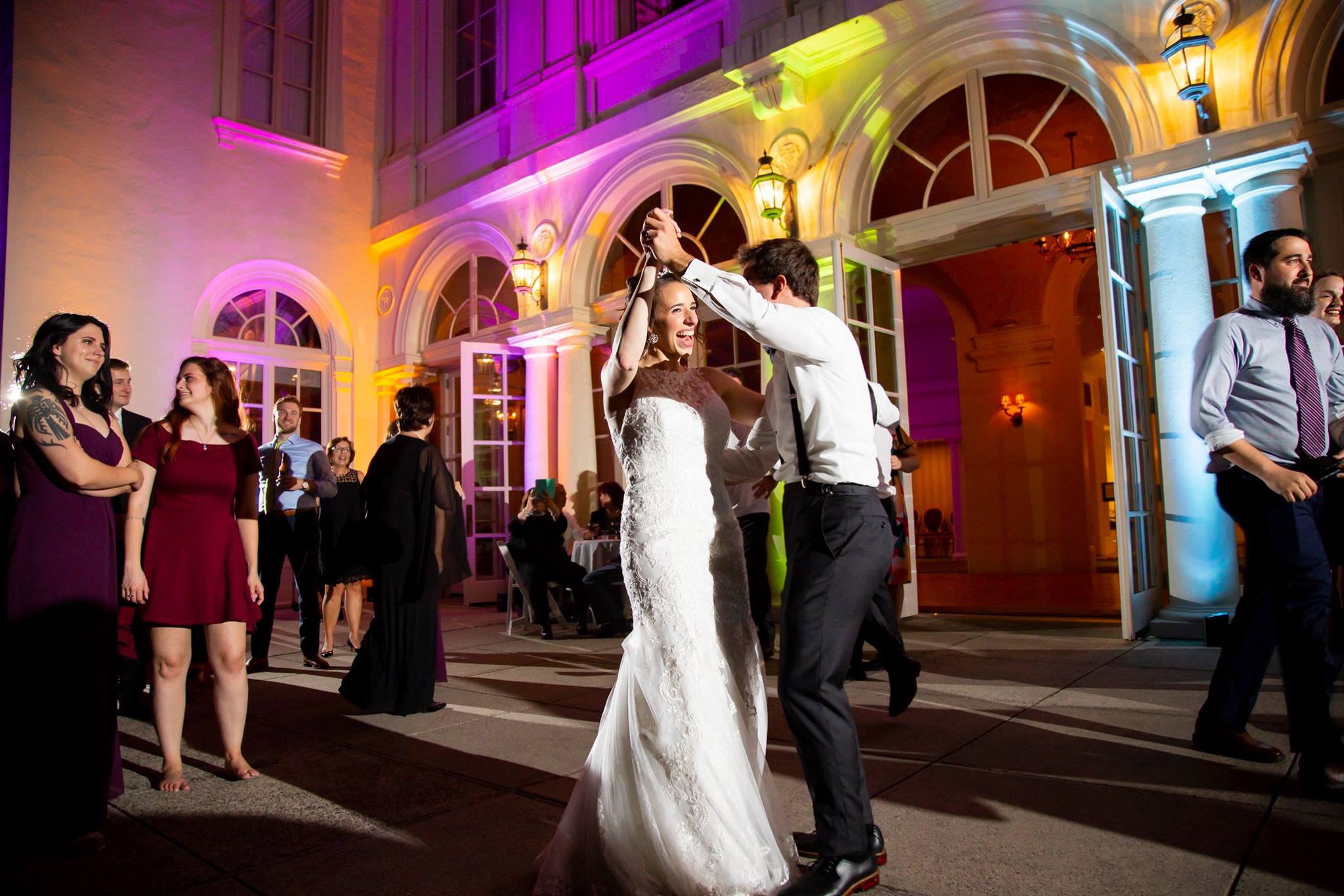 Couple dancing outdoors under colorful up-lighting